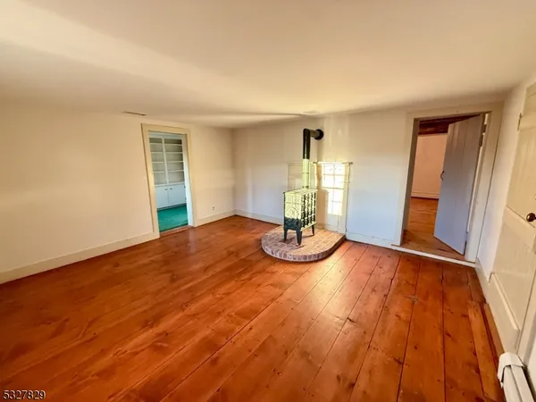 a view of a room with wooden floor table and chairs
