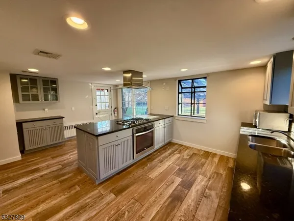 a kitchen with stainless steel appliances kitchen island granite countertop a stove a sink and a refrigerator