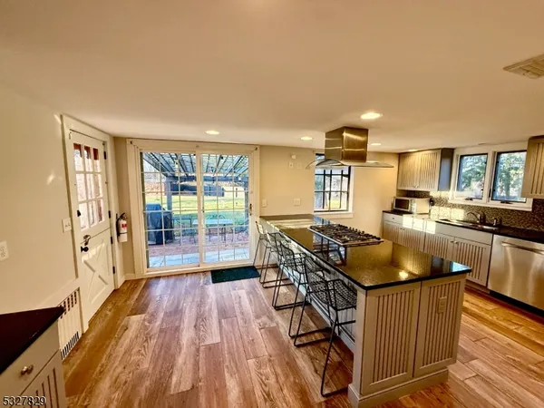 a kitchen with stainless steel appliances granite countertop a stove and a wooden floors