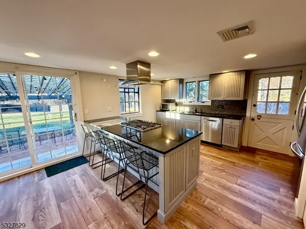 a kitchen with stainless steel appliances granite countertop a stove and a wooden floors