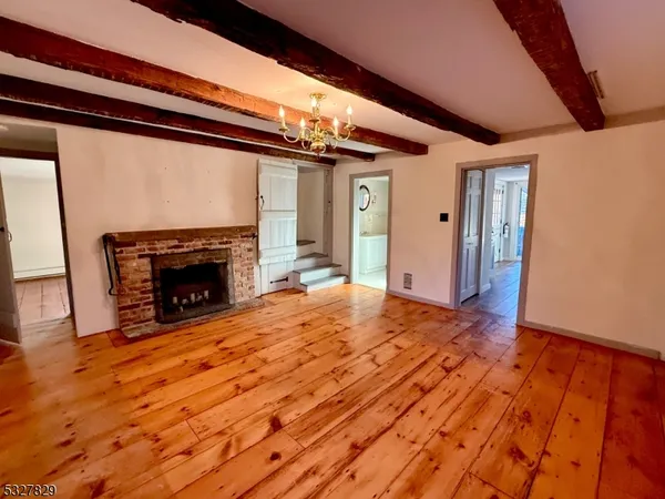 a view of empty room with wooden floor and fireplace