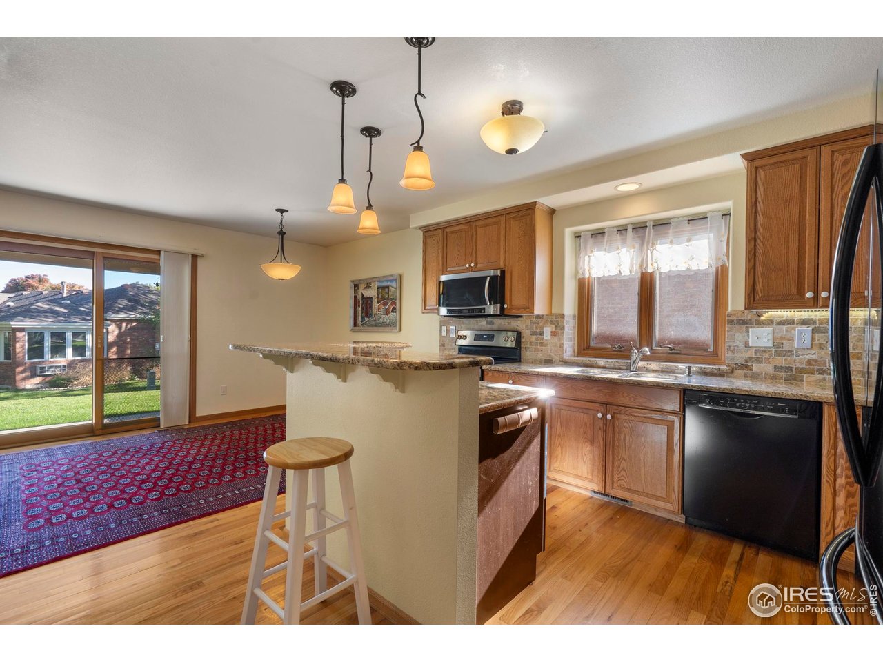 4467 West 17th Street Greeley, CO 80634 - Photo 13 of 48 a kitchen with kitchen island granite countertop a sink cabinets and stainless steel appliances