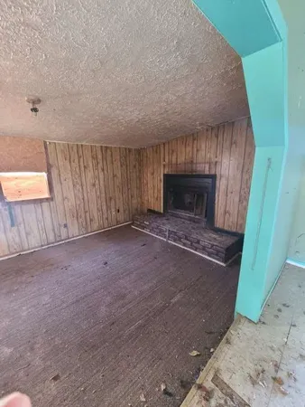 a view of empty room with fireplace and wooden floor