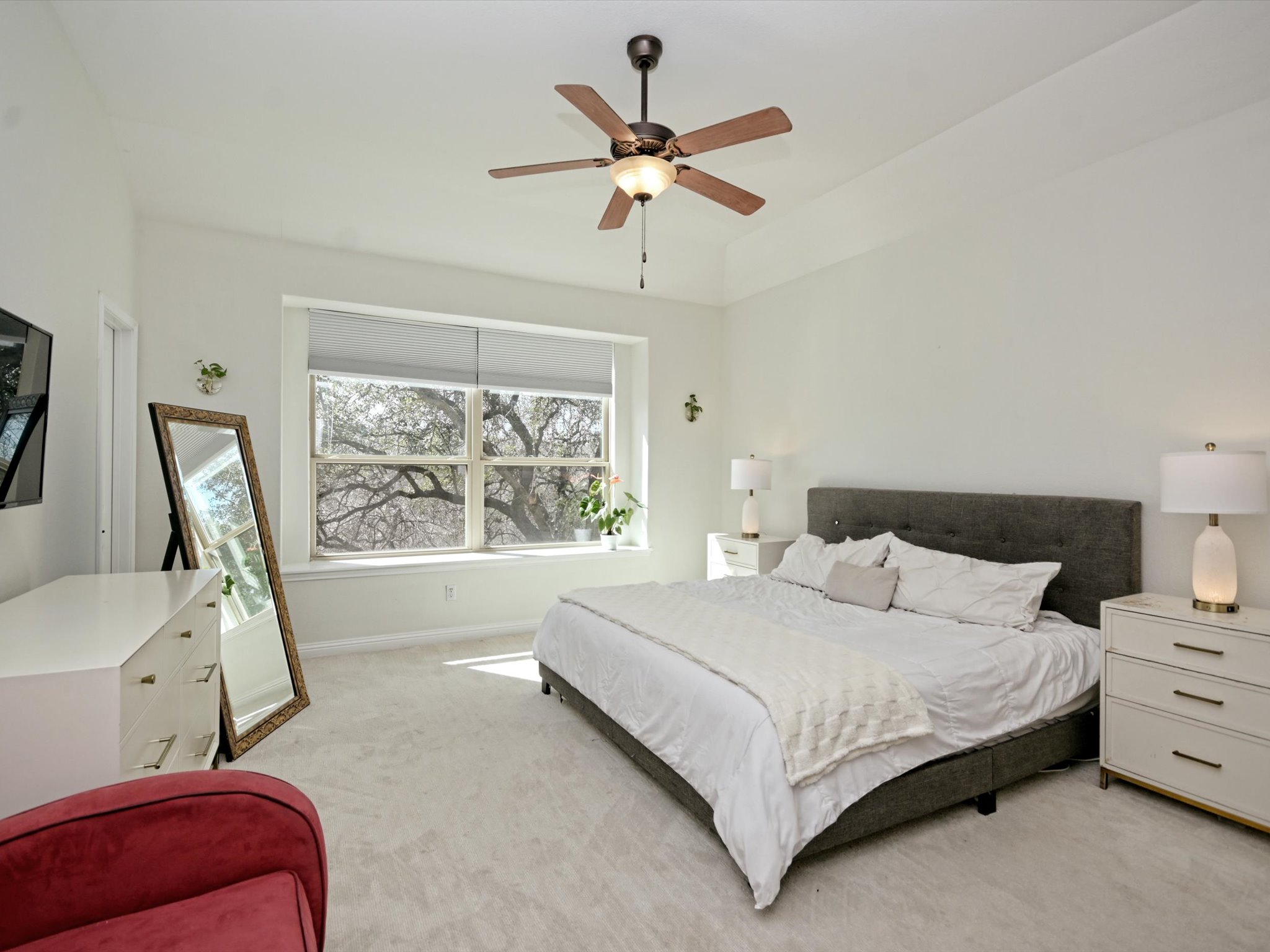 201 Bellagio Drive Austin, TX 78734 - Photo 14 of 31 The bright and spacious primary suite sits under soaring vaulted ceilings with cozy carpeting and a picture window with a ledge.