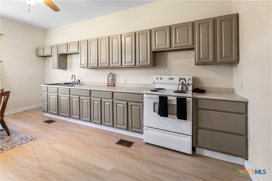 1002 East Commercial Street Victoria, TX 77901 - Photo 11 of 30 a kitchen with stainless steel appliances granite countertop a sink stove and cabinets