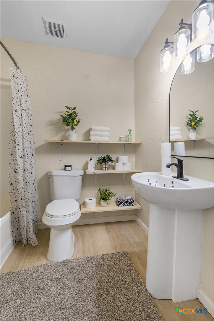 1002 East Commercial Street Victoria, TX 77901 - Photo 16 of 30 a bathroom with a sink a toilet and a mirror