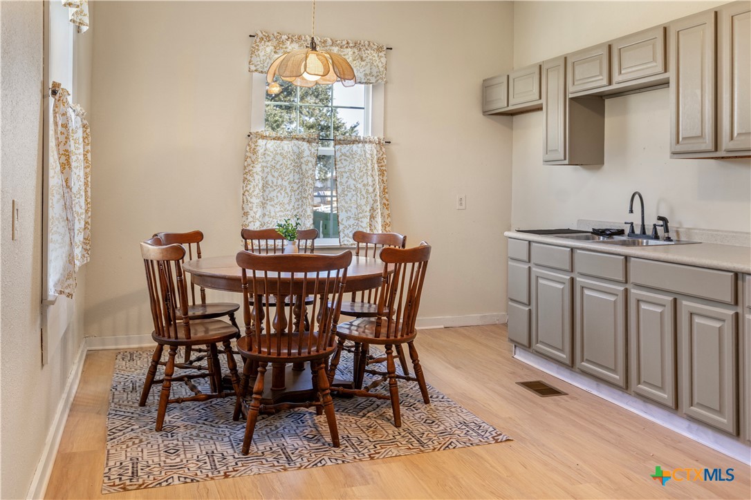1002 East Commercial Street Victoria, TX 77901 - Photo 10 of 30 a view of a dining room with furniture a chandelier and wooden floor