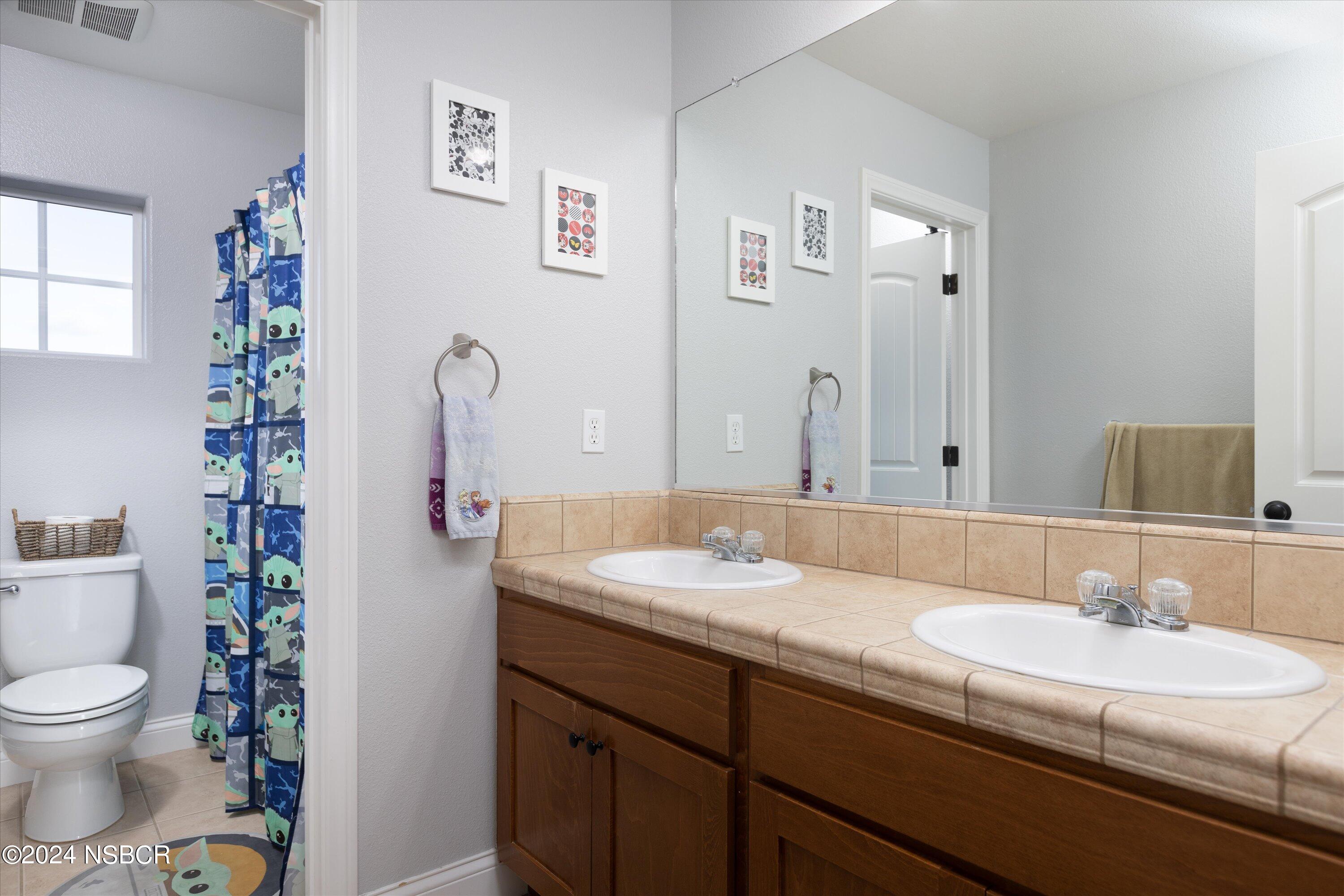 757 Pluto Avenue Lompoc, CA 93436 - Photo 17 of 41 a bathroom with a granite countertop sink and a mirror