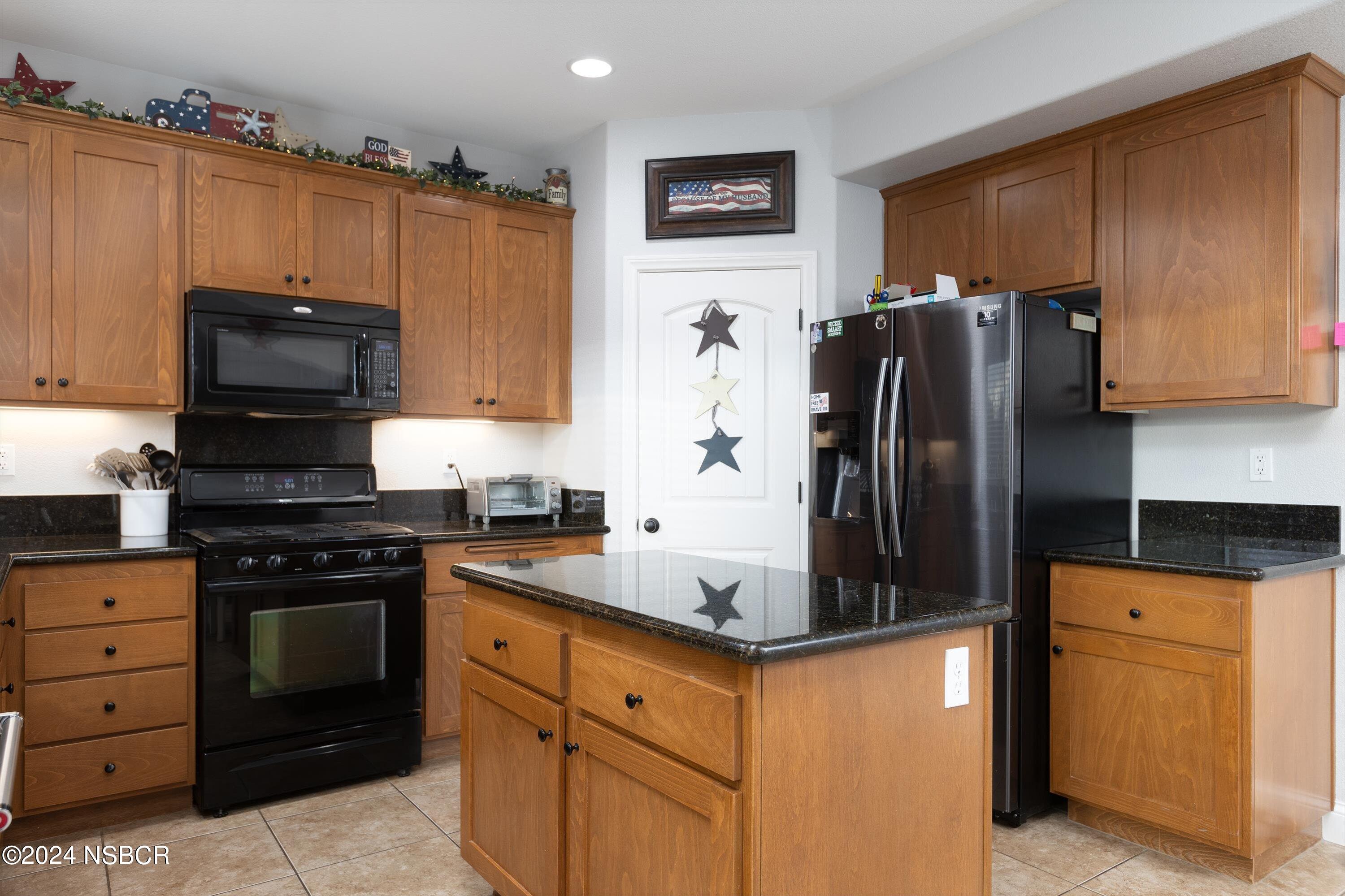 757 Pluto Avenue Lompoc, CA 93436 - Photo 7 of 41 a kitchen with granite countertop a refrigerator stove and microwave