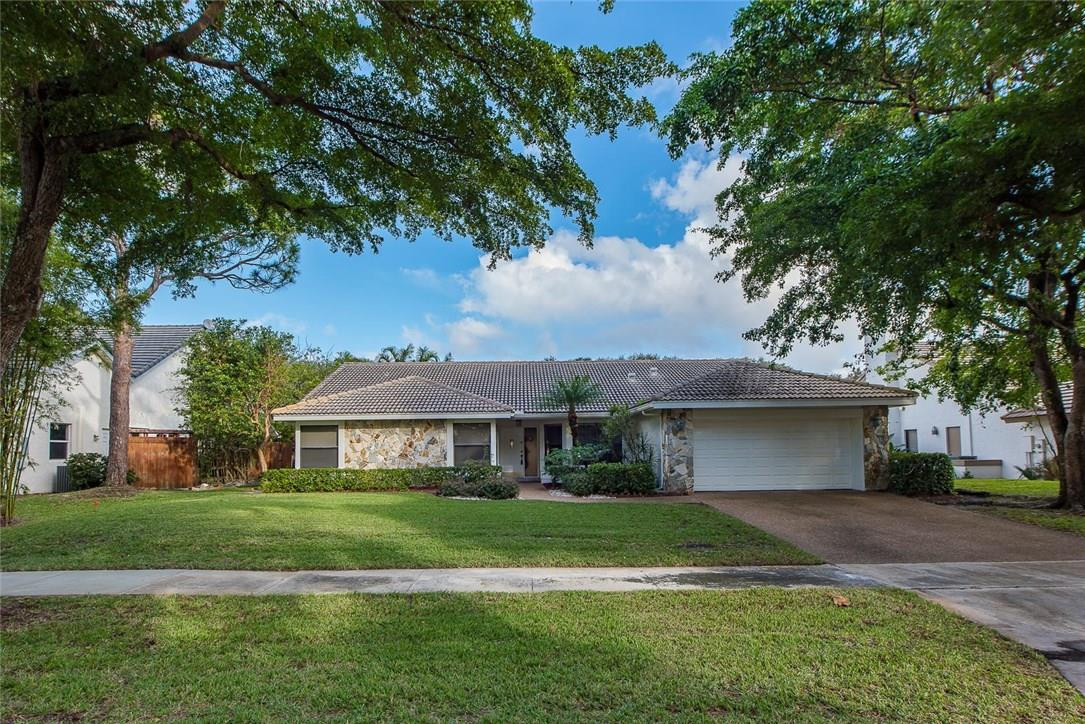 3976 Northwest 23rd Terrace Boca Raton, FL 33431 - Photo 1 of 31 a front view of a house with a garden