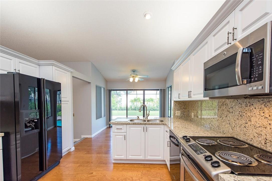 3976 Northwest 23rd Terrace Boca Raton, FL 33431 - Photo 14 of 31 a kitchen with stainless steel appliances granite countertop a stove a sink and a microwave