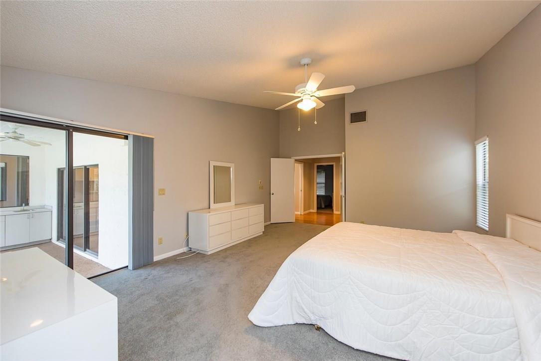 3976 Northwest 23rd Terrace Boca Raton, FL 33431 - Photo 19 of 31 a spacious bedroom with a large bed and a chandelier