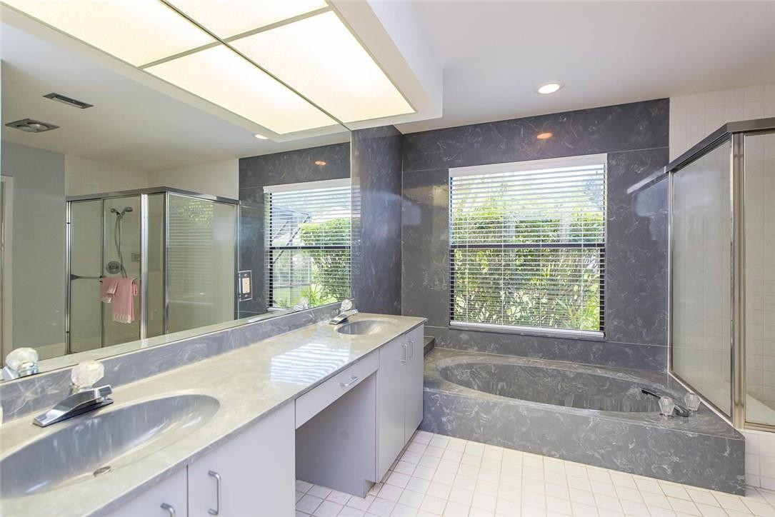 3976 Northwest 23rd Terrace Boca Raton, FL 33431 - Photo 20 of 31 a bathroom with a granite countertop bathtub sink vanity and mirror