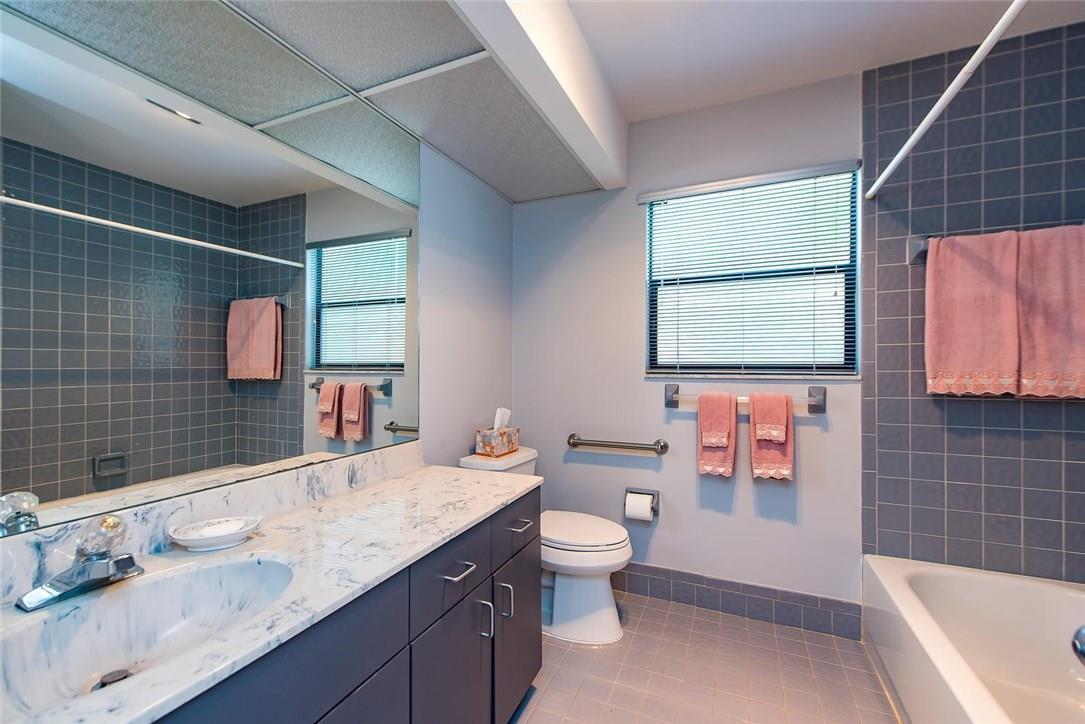 3976 Northwest 23rd Terrace Boca Raton, FL 33431 - Photo 23 of 31 a bathroom with a granite countertop sink a large mirror and a bathtub
