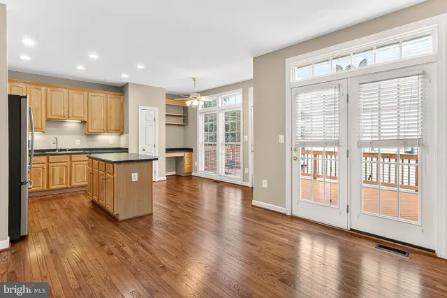 a kitchen with stainless steel appliances wooden floors and wooden cabinets