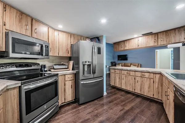 a kitchen with granite countertop a refrigerator stove and microwave