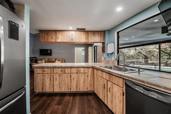 a kitchen with stainless steel appliances granite countertop a sink and wooden cabinets
