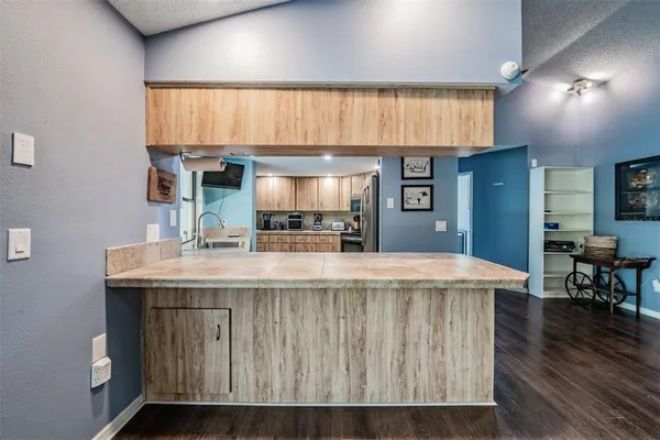 a kitchen with kitchen island a counter top space a sink stainless steel appliances and cabinets
