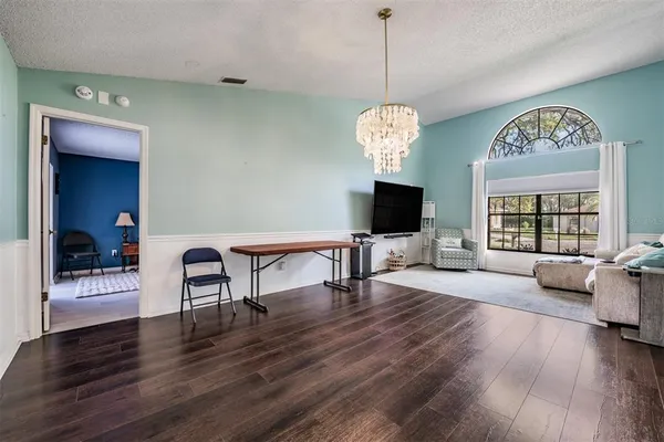 a view of a livingroom with furniture wooden floor a chandelier