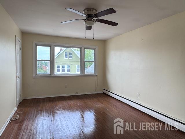 760 Mary Street, Unit B Perth Amboy, NJ 08861 - Photo 2 of 10 an empty room with wooden floor chandelier fan and windows