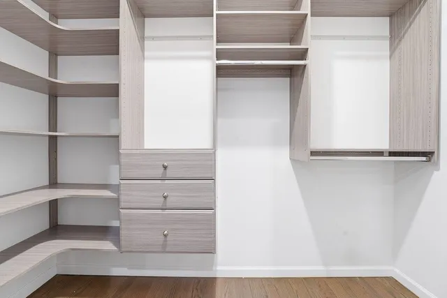 a view of walk in closet with empty racks