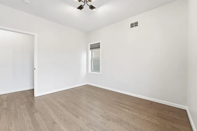 an empty room with a window and a ceiling fan