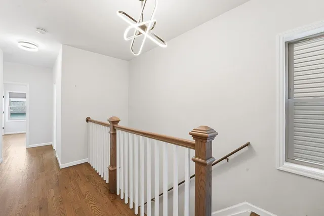 a view of a hallway with a window and wooden floor