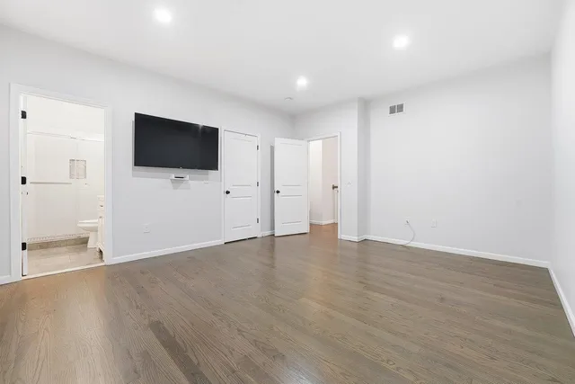 a view of a livingroom with wooden floor and a flat screen tv