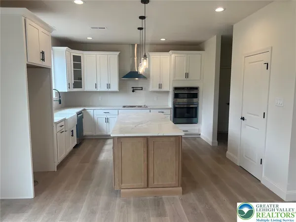 a large kitchen with stainless steel appliances cabinets a wooden floor and a sink