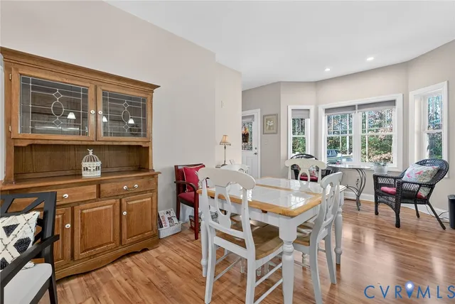 a dining hall with stainless steel appliances granite countertop a dining table and chairs with wooden floor