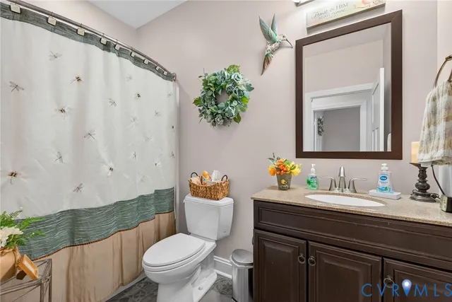 a bathroom with a granite countertop sink and a toilet
