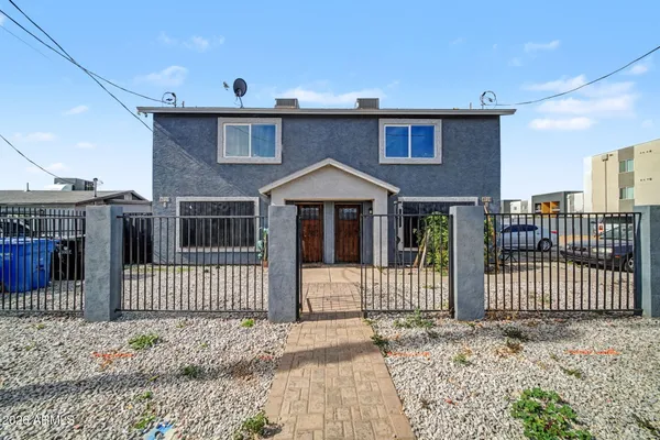 a front view of a house with iron fence