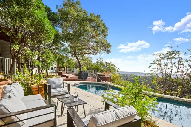 a view of a patio with couches table and chairs and potted plants