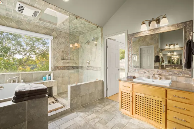 a bathroom with a double vanity sink a mirror and a shower