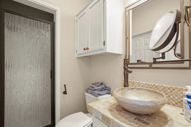 a bathroom with a granite countertop toilet and a mirror