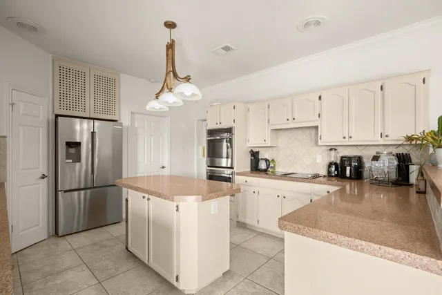 a kitchen with stainless steel appliances granite countertop a refrigerator oven a sink a stove and white cabinets