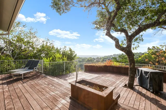 a view of a balcony with wooden floor and outdoor seating