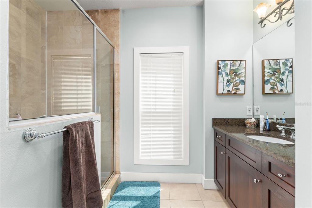 2223 Amherst Avenue Orlando, FL 32804 - Photo 26 of 64 a bathroom with a granite countertop sink a vanity a window and a mirror