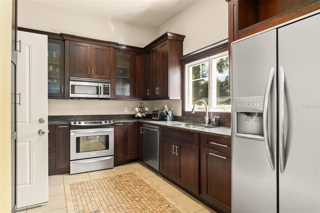 2223 Amherst Avenue Orlando, FL 32804 - Photo 43 of 64 a kitchen with stainless steel appliances granite countertop a refrigerator and a stove top oven