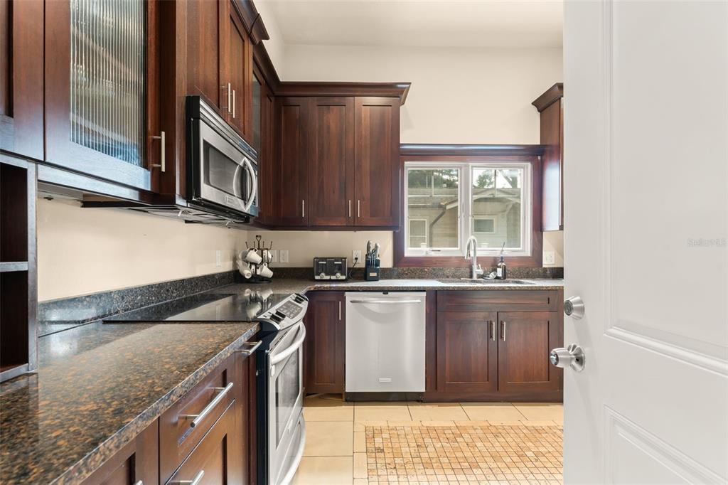 2223 Amherst Avenue Orlando, FL 32804 - Photo 44 of 64 a kitchen with granite countertop a sink stove and cabinets