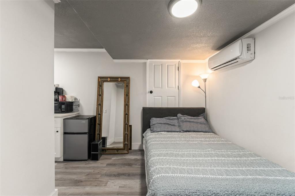 2223 Amherst Avenue Orlando, FL 32804 - Photo 51 of 64 a bedroom with a bed and a refrigerator