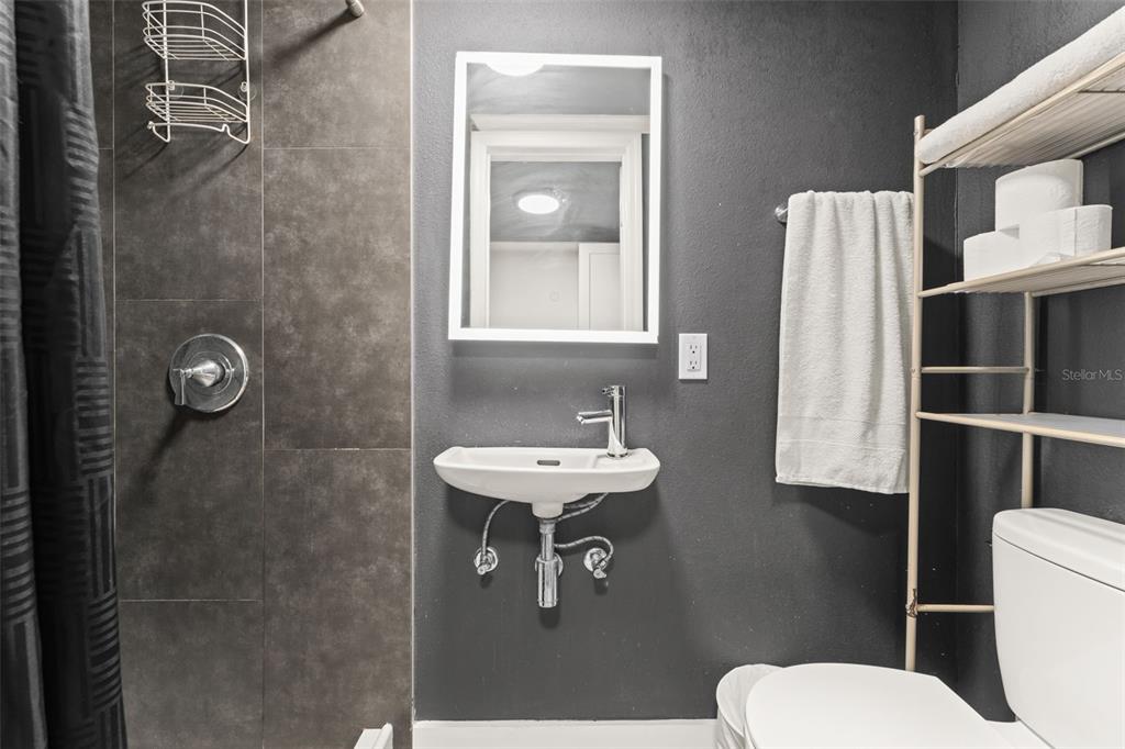 2223 Amherst Avenue Orlando, FL 32804 - Photo 53 of 64 a bathroom with a toilet a sink and mirror