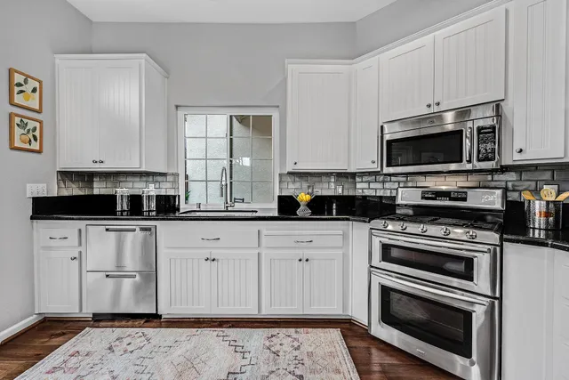 a kitchen with granite countertop a sink and a stove