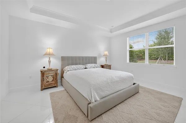 a room with a baby bed and a chandelier