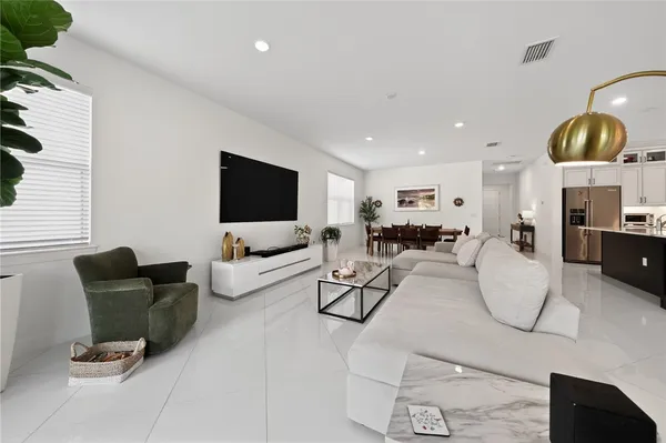a living room with furniture a flat screen tv and a large window