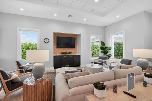 a dining room with furniture a large window and a flat screen tv