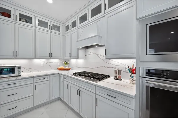 a kitchen with white cabinets and appliances