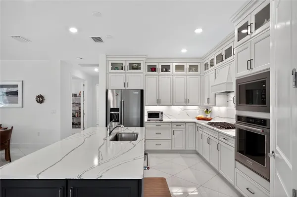 a kitchen with stainless steel appliances kitchen island granite countertop a sink and cabinets