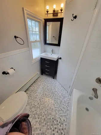a bathroom with a bathtub sink and mirror