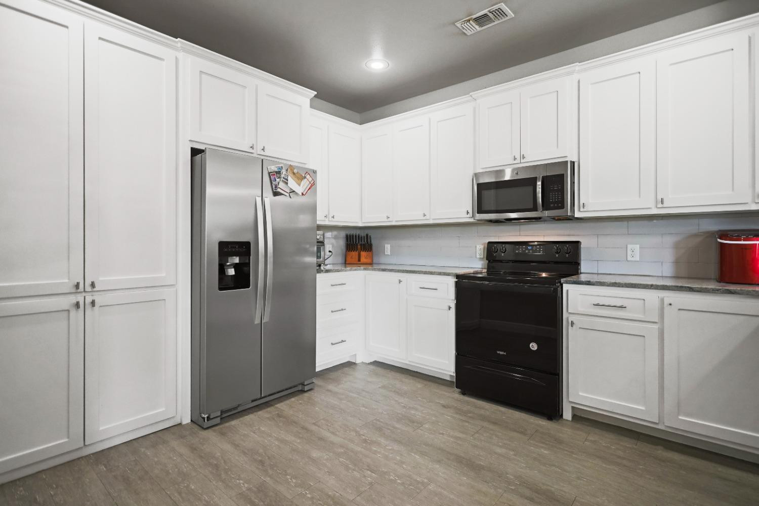 5227 Lehigh Street Lubbock, TX 79416 - Photo 13 of 33 a kitchen with a refrigerator and white cabinets